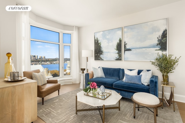 living room with visible vents, baseboards, and a water view