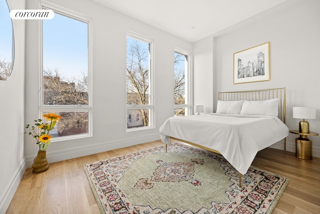 bedroom with baseboards and wood finished floors