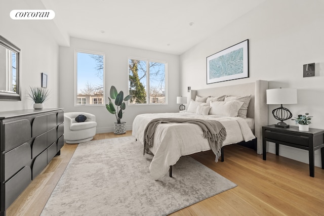 bedroom with light wood-style floors, visible vents, and baseboards