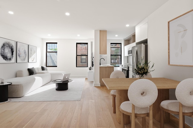 living area with recessed lighting, light wood-type flooring, and baseboards