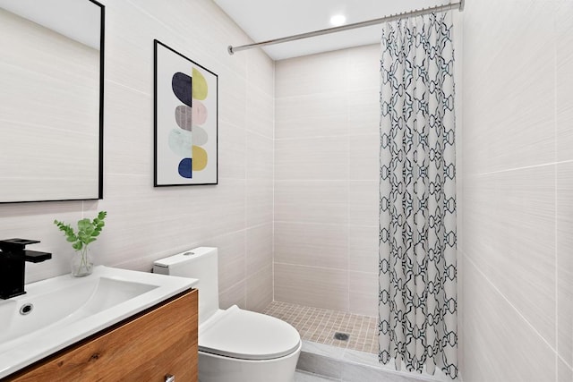 bathroom featuring vanity, tiled shower, tile walls, and toilet