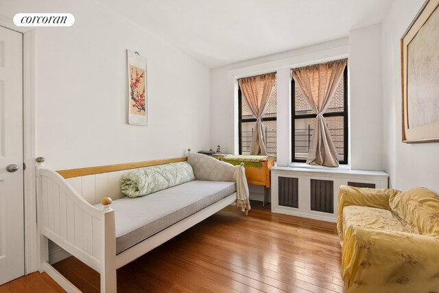 living area with hardwood / wood-style flooring and radiator