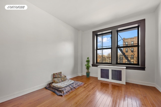 unfurnished room featuring hardwood / wood-style floors and radiator