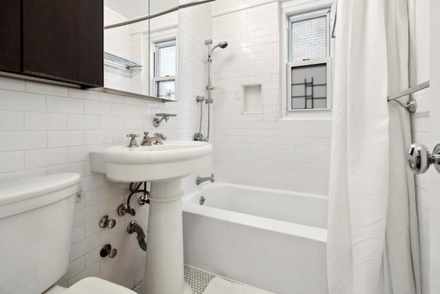 bathroom featuring tile walls, shower / bath combo, tasteful backsplash, and toilet