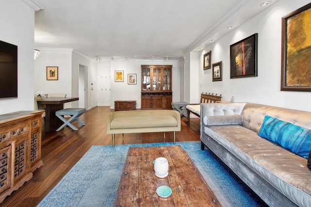 living area featuring baseboards, track lighting, ornamental molding, and hardwood / wood-style floors