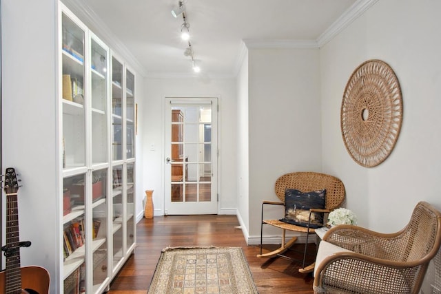 living area with ornamental molding, rail lighting, and dark wood-type flooring