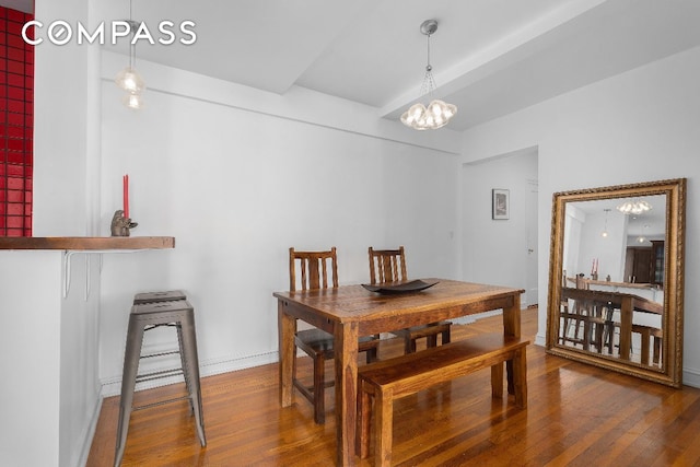 dining space featuring a notable chandelier, baseboards, and wood finished floors