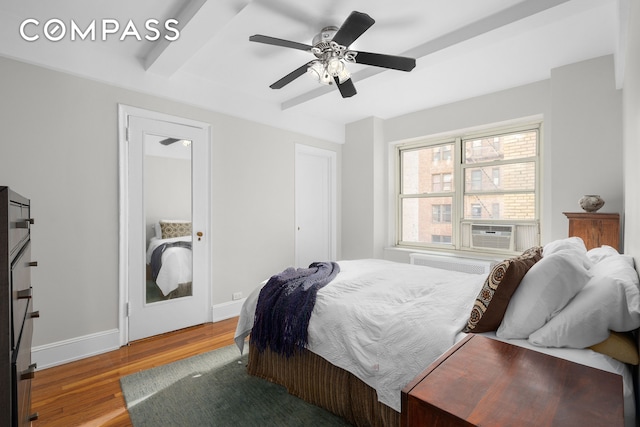 bedroom with beamed ceiling, wood finished floors, cooling unit, baseboards, and ceiling fan