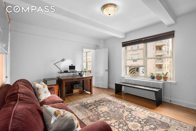 living room featuring beamed ceiling, wood-type flooring, and radiator heating unit