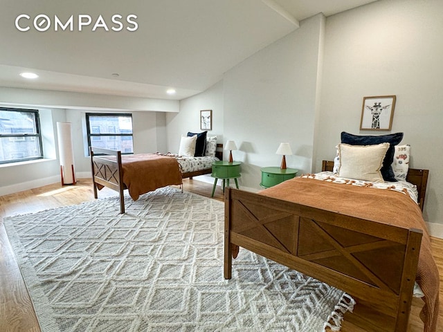 bedroom featuring recessed lighting, baseboards, light wood-style flooring, and vaulted ceiling