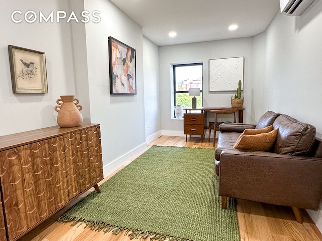 living area with recessed lighting, an AC wall unit, baseboards, and wood finished floors