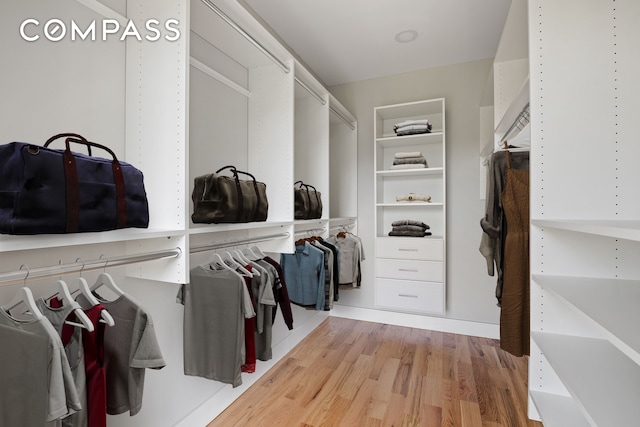 walk in closet with wood finished floors