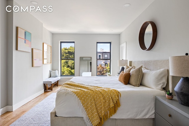 bedroom with light wood-type flooring and baseboards