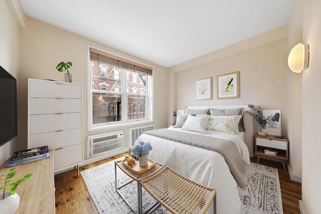 bedroom with hardwood / wood-style flooring and a wall mounted AC