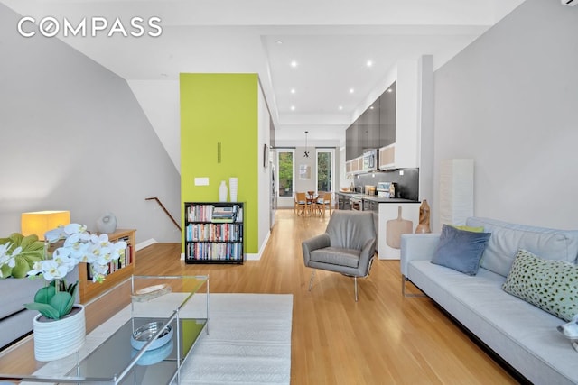 living room with light hardwood / wood-style floors and a high ceiling