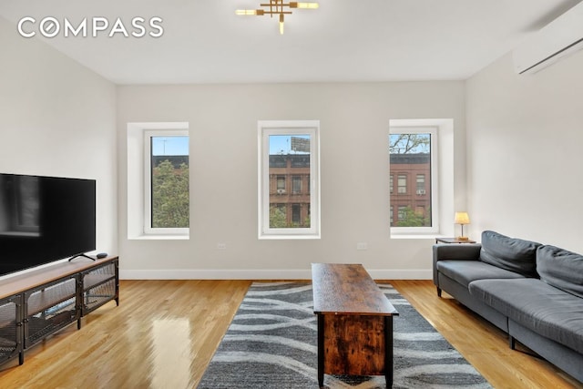 living room with light hardwood / wood-style floors and a wall unit AC