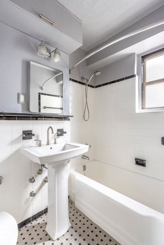 225 E 46th St Unit 12B, New York City, NY 10017 - full bathroom featuring shower / washtub combination, toilet, and tile walls