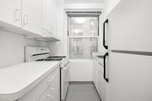 kitchen with white cabinetry, white appliances, and light tile patterned flooring