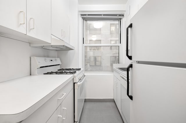 215 E 73rd St Unit 1G, New York City, NY 10021 - kitchen with white appliances, under cabinet range hood, white cabinetry, light countertops, and light tile patterned floors