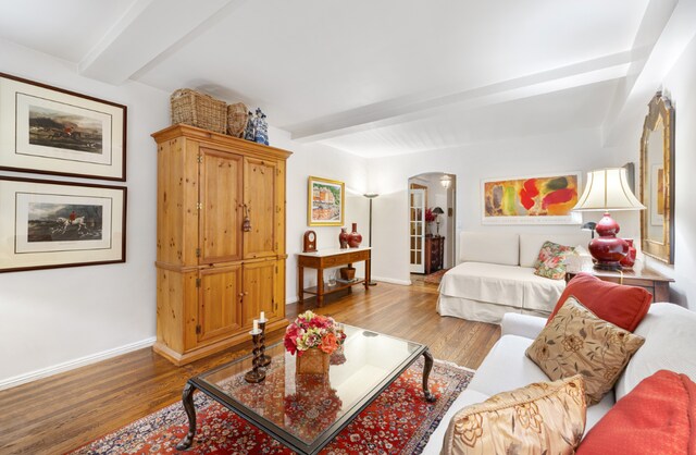 living room with beam ceiling and light hardwood / wood-style flooring