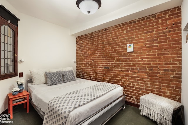 carpeted bedroom with brick wall