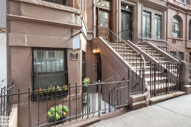 doorway to property with cooling unit and fence