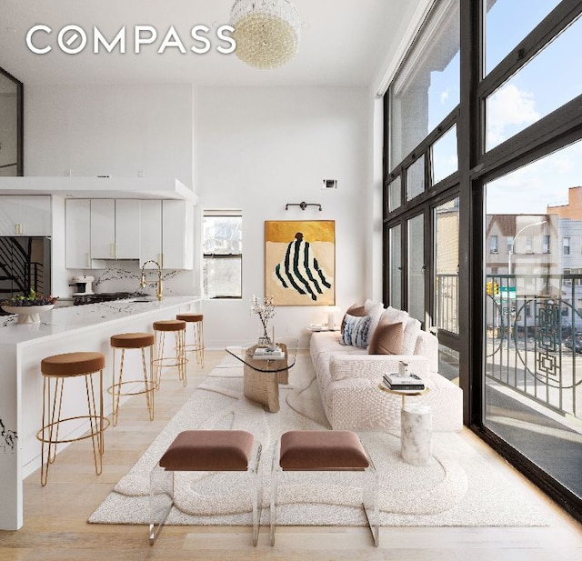 living area featuring visible vents, a high ceiling, and light wood-style flooring