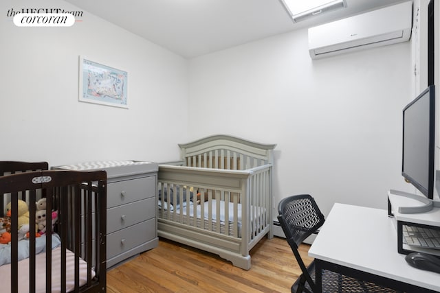 bedroom with wood finished floors and a wall mounted AC