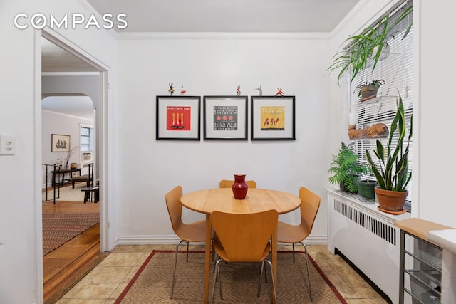 95 Park Ter E Unit 3B, New York City, NY 10034 - dining space with radiator, crown molding, arched walkways, and baseboards