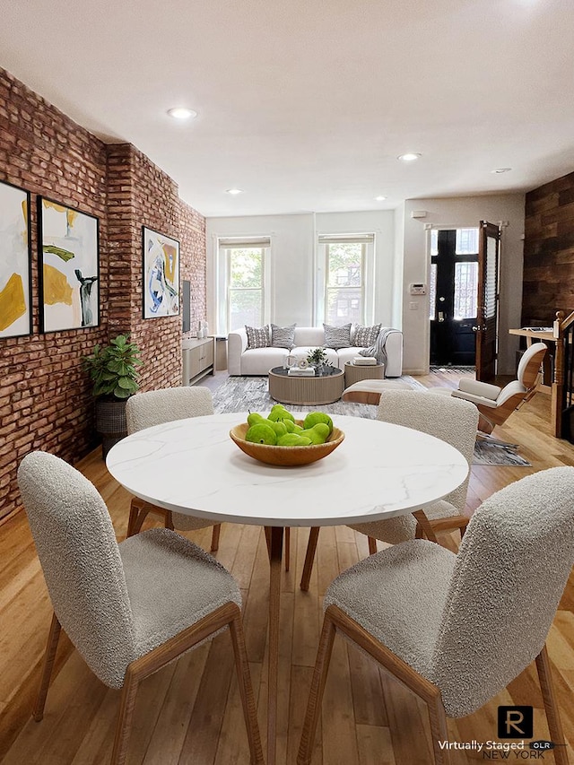dining room featuring recessed lighting, brick wall, and light wood finished floors
