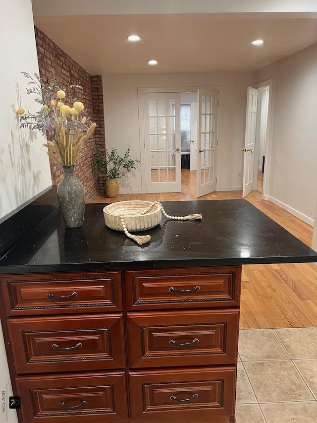 kitchen with dark stone counters, recessed lighting, french doors, and light tile patterned flooring