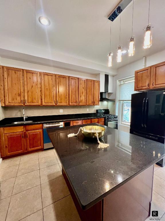 kitchen featuring sink, hanging light fixtures, a center island, black appliances, and wall chimney exhaust hood