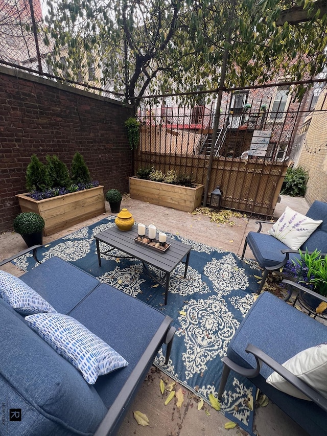 view of patio featuring a garden and fence