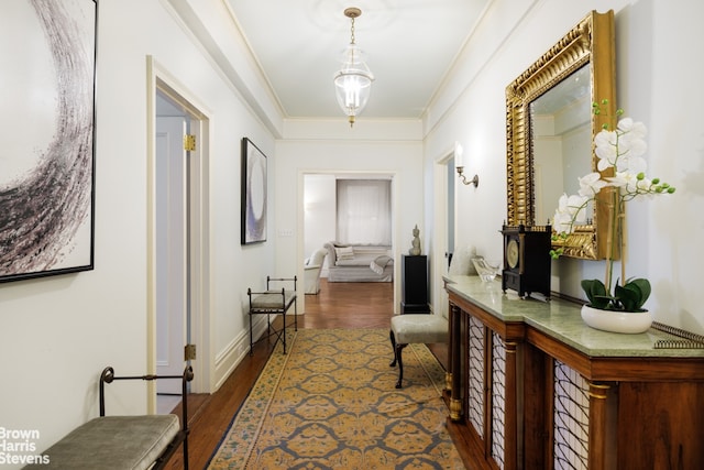 corridor with ornamental molding and dark hardwood / wood-style floors