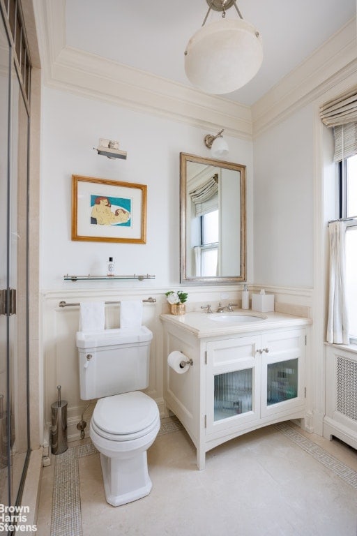 bathroom with vanity, crown molding, and toilet