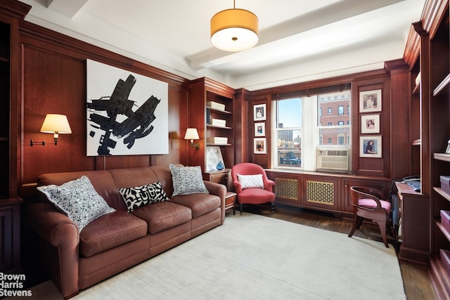 sitting room with cooling unit, hardwood / wood-style floors, and beam ceiling