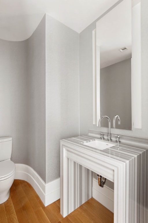 bathroom featuring hardwood / wood-style floors, sink, and toilet