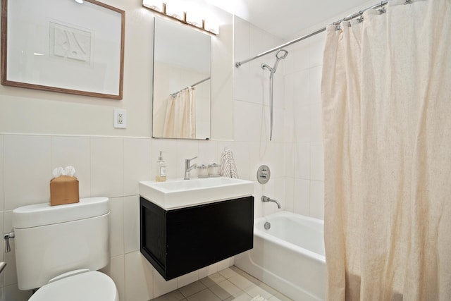 bathroom with tile walls, toilet, shower / bath combo, vanity, and tile patterned floors