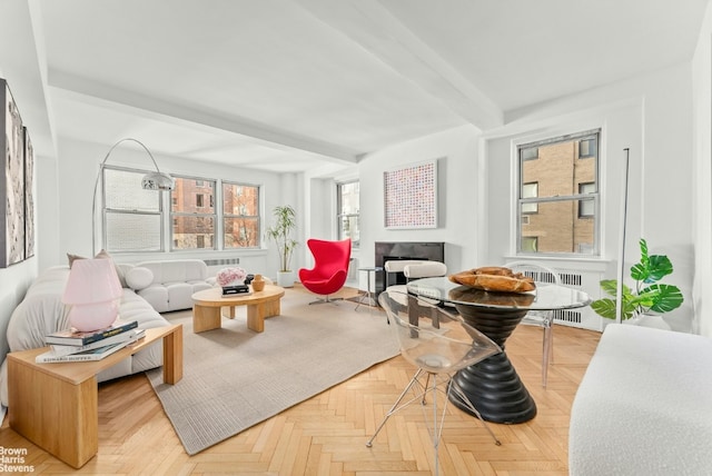 interior space featuring beamed ceiling, a fireplace, radiator, and light parquet floors