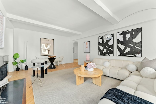 living room with hardwood / wood-style flooring, a fireplace, and beam ceiling