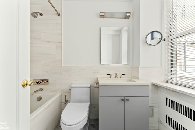 bathroom with tile walls, toilet, vanity, and radiator heating unit