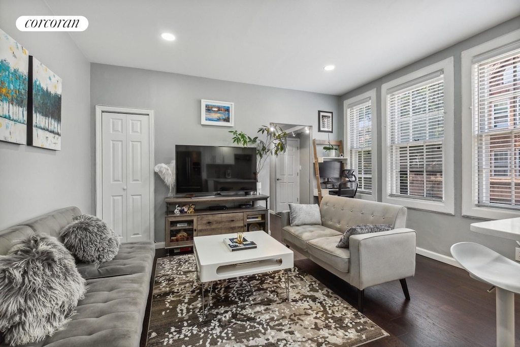 living area with baseboards, visible vents, wood finished floors, and recessed lighting