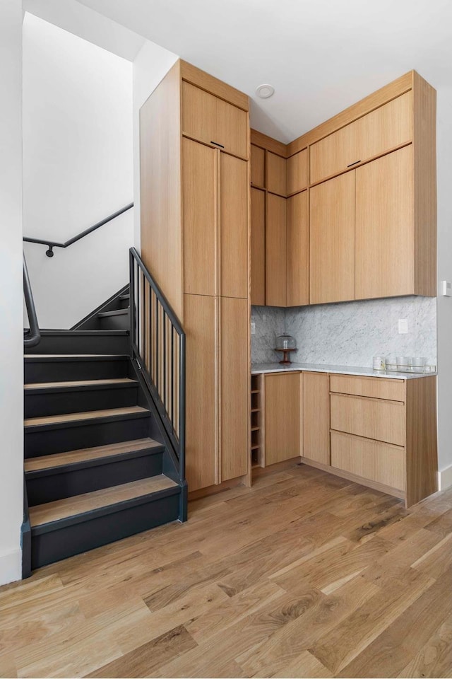 kitchen featuring light wood-type flooring, modern cabinets, and decorative backsplash