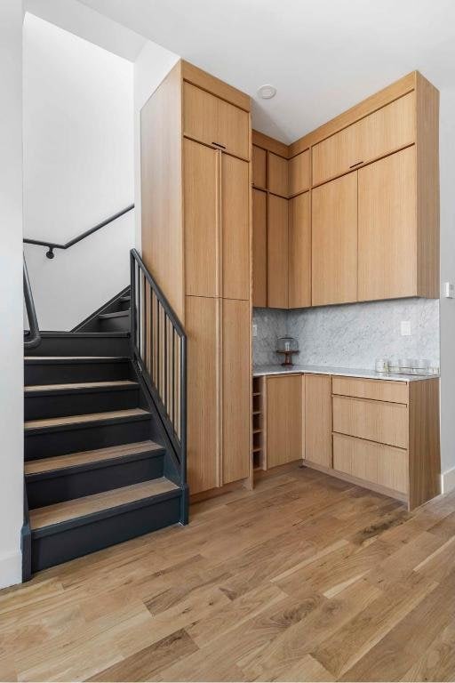 kitchen featuring light brown cabinets, backsplash, and light hardwood / wood-style floors