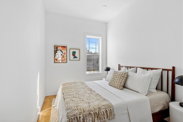 bedroom with light wood finished floors and baseboards