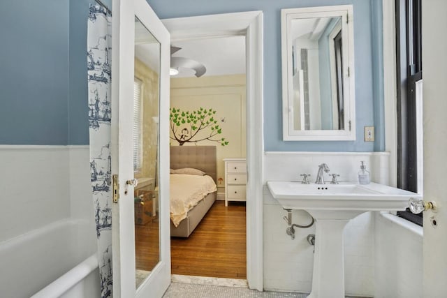 bathroom with sink, wood-type flooring, and a bathing tub