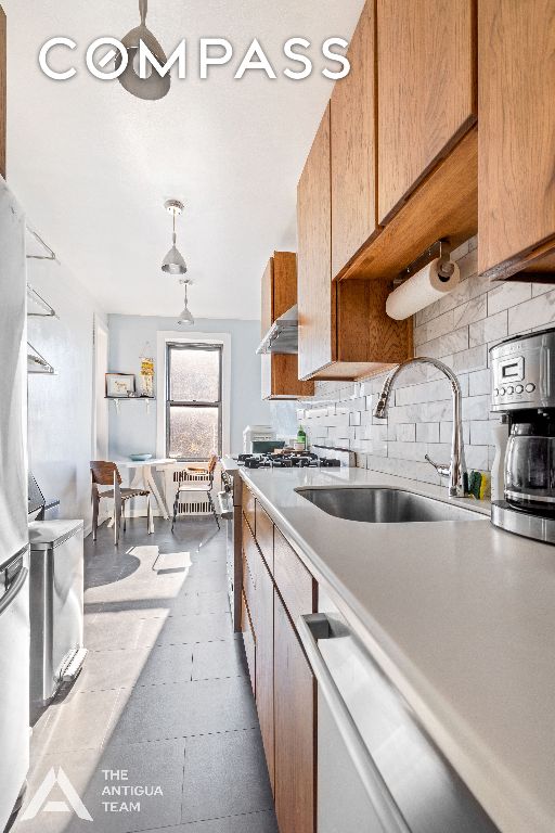 kitchen with pendant lighting, sink, and decorative backsplash