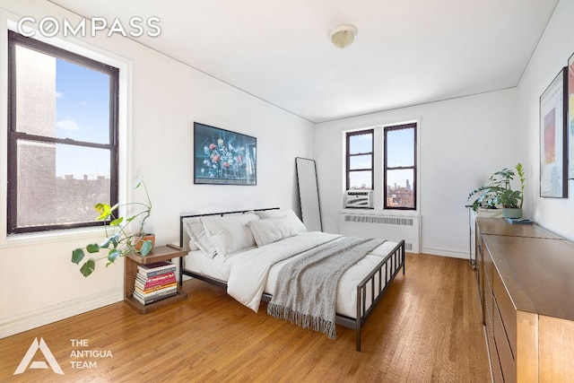 bedroom featuring wood-type flooring and radiator