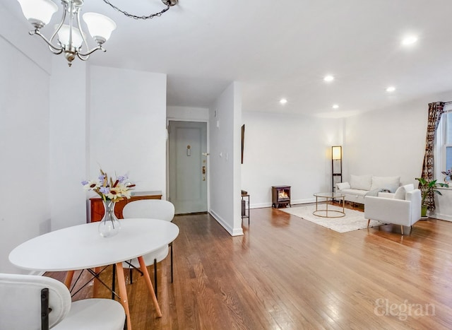 dining space featuring hardwood / wood-style floors and a chandelier