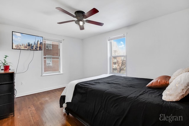 bedroom featuring wood finished floors, a ceiling fan, and baseboards